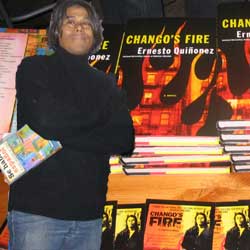 Photo of Ernesto Quinonez in the forfront with enlarged photo of his new book in the background.